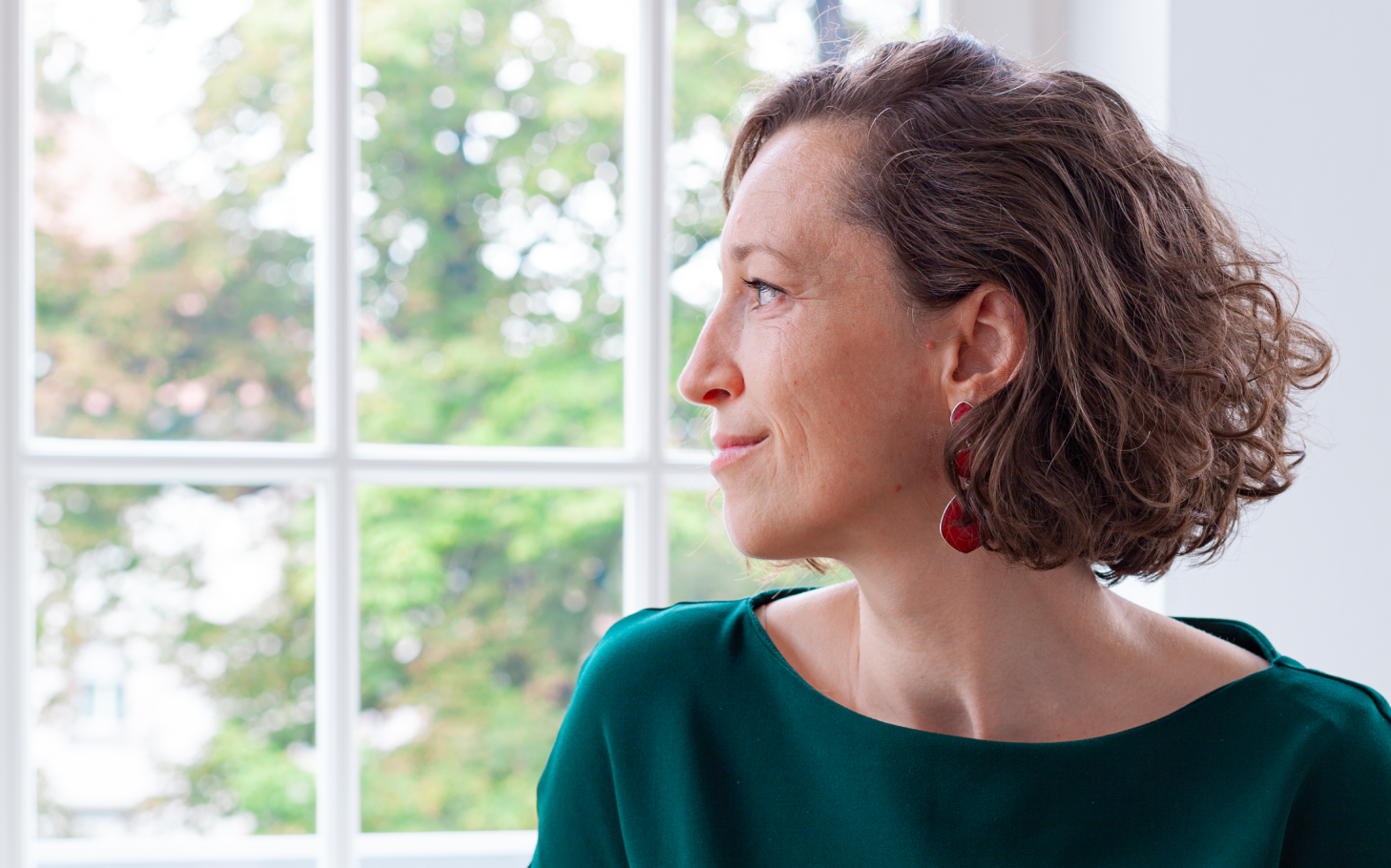 Sonja Mewes Profilbild, aus dem Fenster schauend für Weitblick